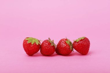 Pembe arka planda ön çilek kompozisyonu