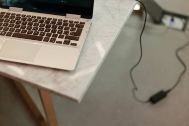 Fotoğrafın bir tarafındaki mermer masada gri dizüstü bilgisayar.