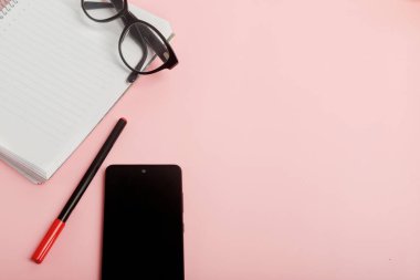 Pembe arka planda gözlüklü ve cep telefonlu ajanda