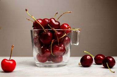 Misket masasında kirazlı cam bardak.