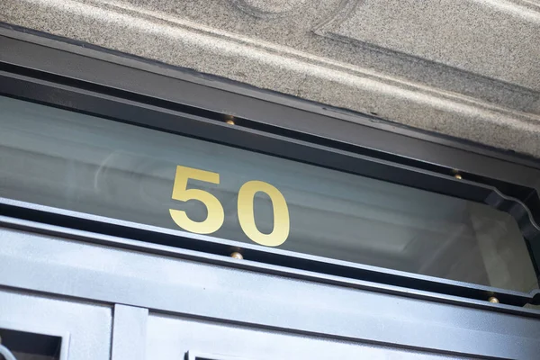 Caddedeki bina girişi 50 numarayı gösteriyor.