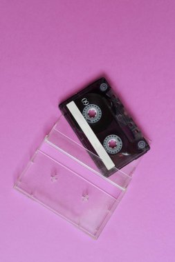 Pembe arka planda şeffaf çantalı düz bir kaset.