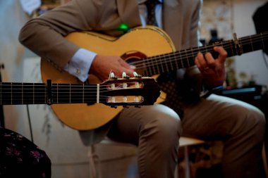 Performans sırasında Capo ile klasik gitar çalan müzisyen