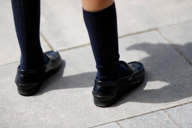 Yüksek çoraplı ve mokasenli çocuk bacakları.