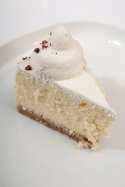 Temiz beyaz arkaplanda bir parça cheesecake