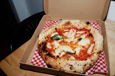 El yapımı pizza teslimat kutusunda masanın üstünde.