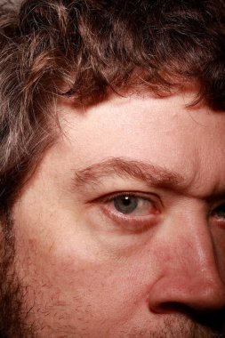 Adam yoğun bir yüz ifadesi sergiliyor, bir düşünceye odaklanıyor.