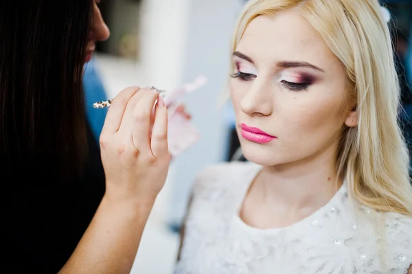 Joven hermosa novia rubia aplicando maquillaje de boda por maquillaje — Foto de Stock