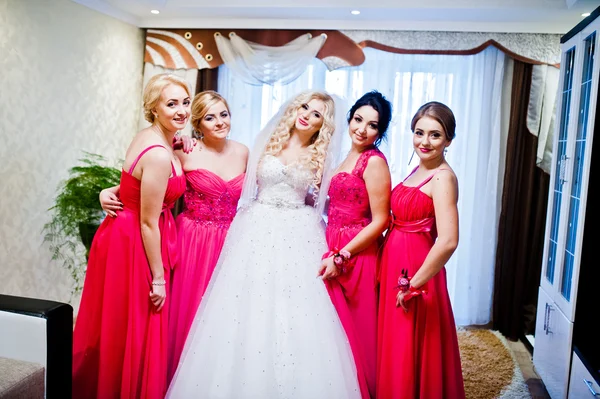 Красивая блондинка невеста с четырьмя волшебными подружками невесты, позирующими в комнате — стоковое фото