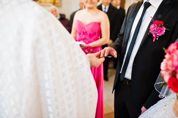 Priest wears a wedding ring on the hand of the groom — Stock Photo, Image