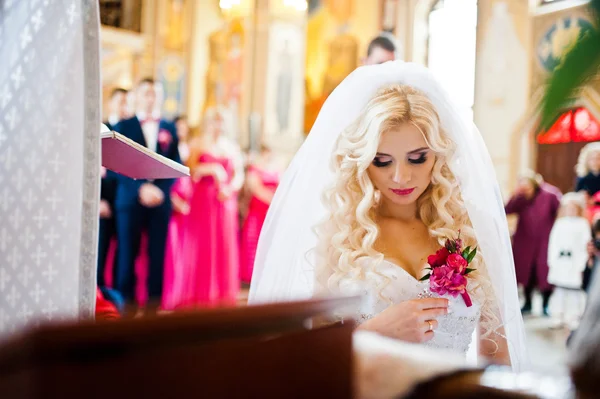 Estilo novia rubia de rodillas en la iglesia — Foto de Stock