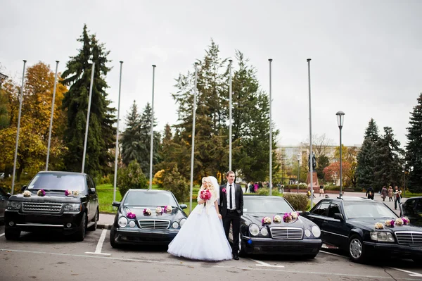 Hochzeitspaar Hintergrund Autos cortege — Stockfoto