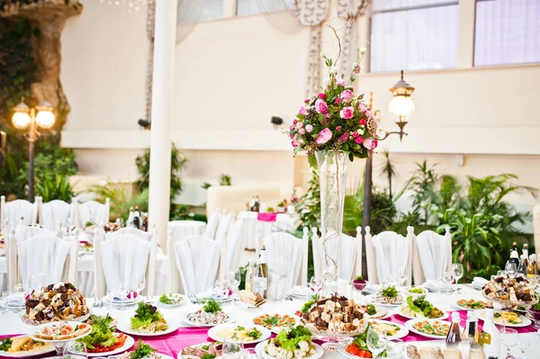 Vase mit Blumen am Tisch der Gäste im Hochzeitsrestaurant — Stockfoto