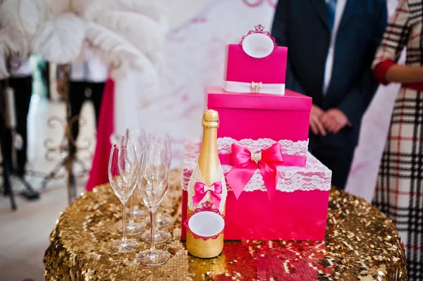 Botella de champán dorado con copas y caja de dinero rosa —  Fotos de Stock