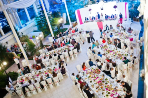 Efecto desenfocado de los invitados en su mesa en la fiesta de bodas —  Fotos de Stock