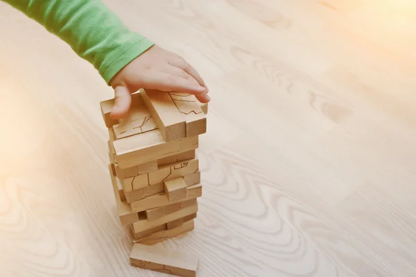 Рука дитини, яка грала в розвиваючу гру з дерев'яних блоків — стокове фото