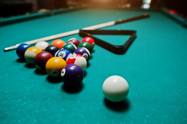 Billiard balls in a pool table at triangle with billiard cue — Stock Photo, Image