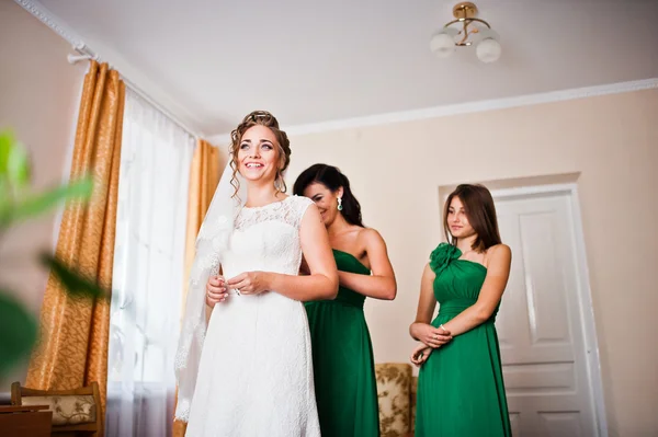Zwei anmutige Brautjungfern auf grünem Kleid tragen süße Braut — Stockfoto