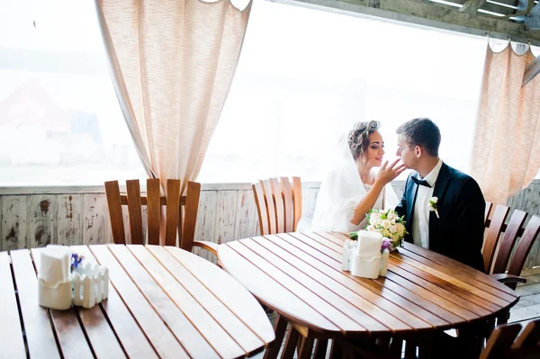 Свадебная пара сидит за столом в кафе — стоковое фото
