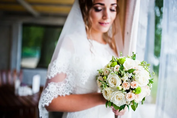 Charmante bruid keek bruiloft boeket op haar handen — Stockfoto