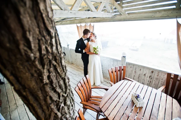 Hochzeitspaar umarmt sich im Holzcafé — Stockfoto