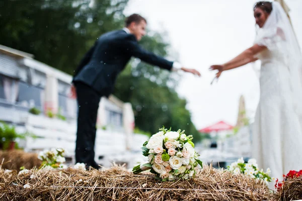 Brautstrauß auf Ballen Hintergrund Hochzeitspaar bei regnerischem Wetter — Stockfoto