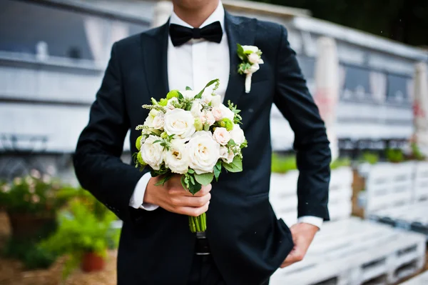 Buquê de casamento na mão do noivo com laço — Fotografia de Stock