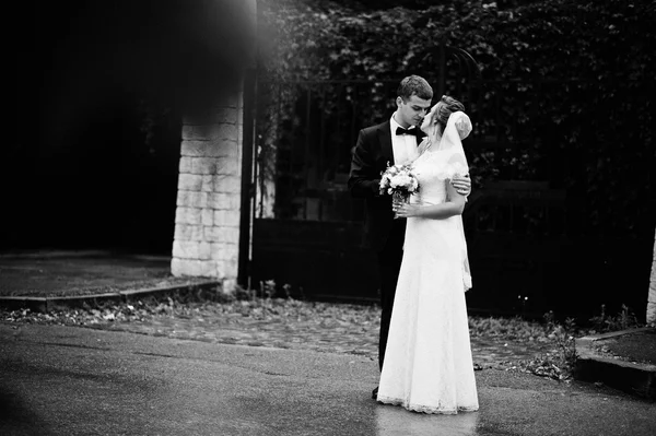 Casamento casal fundo o portão coberto folhagem — Fotografia de Stock