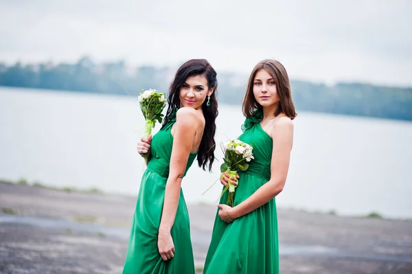 Twee gecharmeerd meisjes bruidsmeisjes op groene jurk — Stockfoto