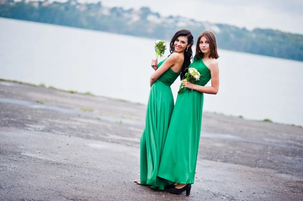 Twee gecharmeerd meisjes bruidsmeisjes op groene jurk — Stockfoto