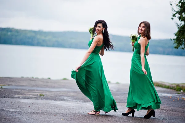 Twee gecharmeerd meisjes bruidsmeisjes op groene jurk — Stockfoto