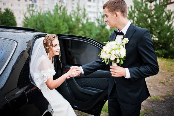 Ženich a nevěsta poblíž svatební auto — Stock fotografie