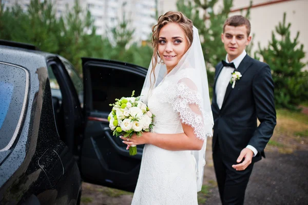 Ženich a nevěsta poblíž svatební auto — Stock fotografie