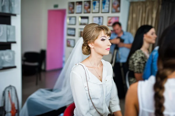 Artista de maquiagem de casamento fazendo uma maquiagem para a noiva . — Fotografia de Stock