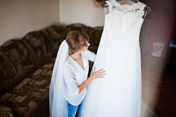 Youn noiva feliz olhou para seu vestido de noiva — Fotografia de Stock