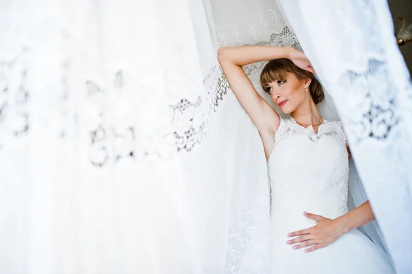 カーテンでポーズをとった若い花嫁 — ストック写真