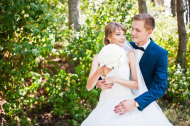 Güneşli bir gün, güzel düğün çift çam ahşap orman üzerinde