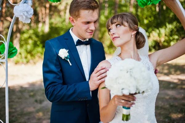 Preciosa pareja de boda en un día soleado en madera de pino cerca de la decoración weddi — Foto de Stock