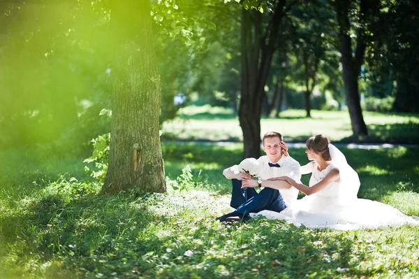 Wedding couple at park near trees and bushes — Stock Photo, Image