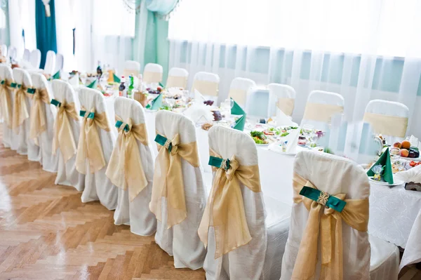 Cadeiras de casamento decoradas com fitas de veludo dourado e verde — Fotografia de Stock