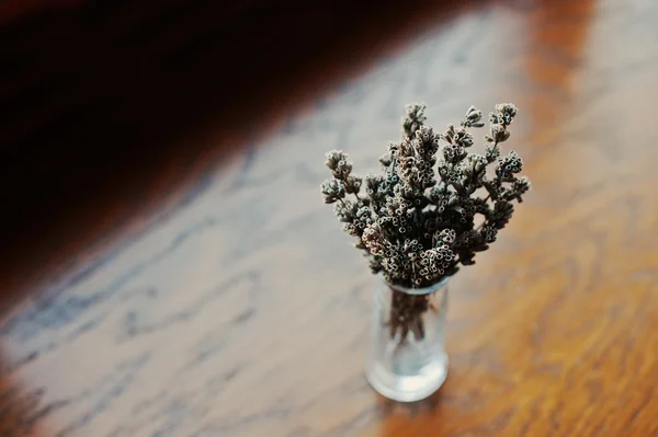 Torkad lavendel grenar på vas på brun trä bakgrund — Stockfoto