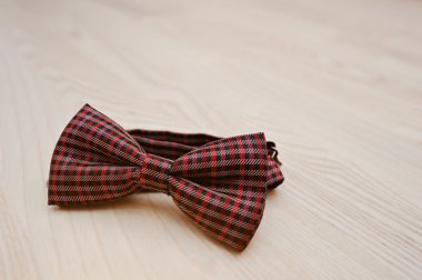 Hafif ahşap arka plan üzerinde kırmızı kareli papyon