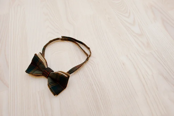 Cotton checkered bow tie on light wooden background — Stock Photo, Image