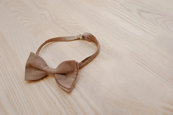 Corbata de lazo a cuadros marrón sobre fondo de madera claro — Foto de Stock
