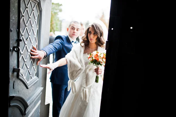 Wedding couple at the gate of the temple church — Stock Photo, Image