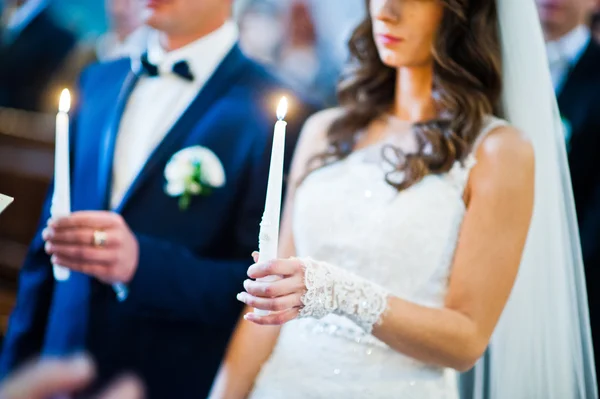 Gazdaság gyertyák, a templom esküvő házaspár — Stock Fotó