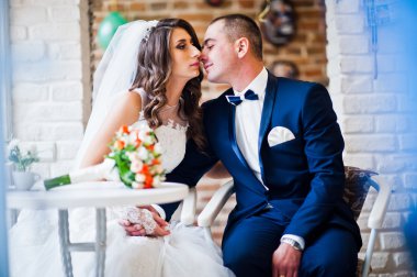 Bir kafede bir masada oturan Düğün çifti