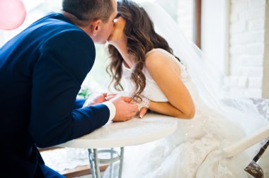 Bir kafede bir masada oturan Düğün çifti