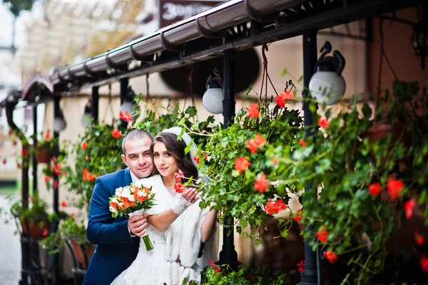 Svatební pár nedaleko café s květinami na terase — Stock fotografie