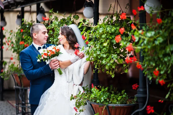 Esküvői pár közeli kávézóban és a teraszon virágok — Stock Fotó